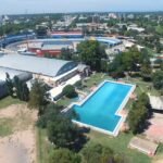 Vista aérea del Club Alianza Jesús María con piscina olímpica, estadio deportivo y edificios rodeados de áreas verdes.