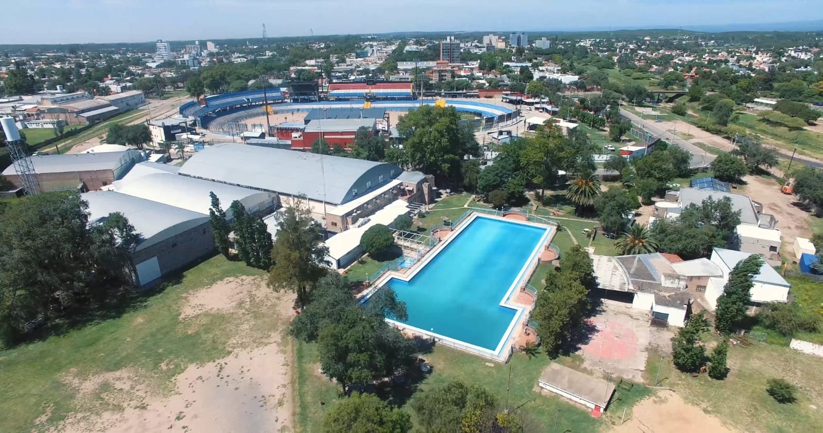 Vista aérea del Club Alianza Jesús María con piscina olímpica, estadio deportivo y edificios rodeados de áreas verdes.